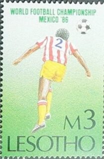 ¿Por qué un país africano sin tradición futbolística emitiría una estampilla sobre el Mundial de México 1986? Lesotho, enclavado completamente dentro de Sudáfrica, encontró en estas emisiones deportivas una ventana al mundo. 

Durante los años del apartheid, cuando la región vivía aislamiento internacional, países como Lesotho usaban la filatelia para proyectar una identidad propia y conectar con eventos globales. Esta pieza de mi colección, con su valor de 3 maloti, celebra no solo el torneo que consagró a Maradona, sino el fútbol como lenguaje universal que trasciende fronteras. 

México '86 se convirtió en tema filatélico mundial: desde Albania hasta Zimbabwe, decenas de países emitieron series similares. El fútbol había demostrado ser el primer verdadero fenómeno mediático global, y las estampillas fueron testigos de papel de esta transformación cultural.

#FilateliaDeportiva #Mundial #Lesotho #WorldCupStamps #Sports